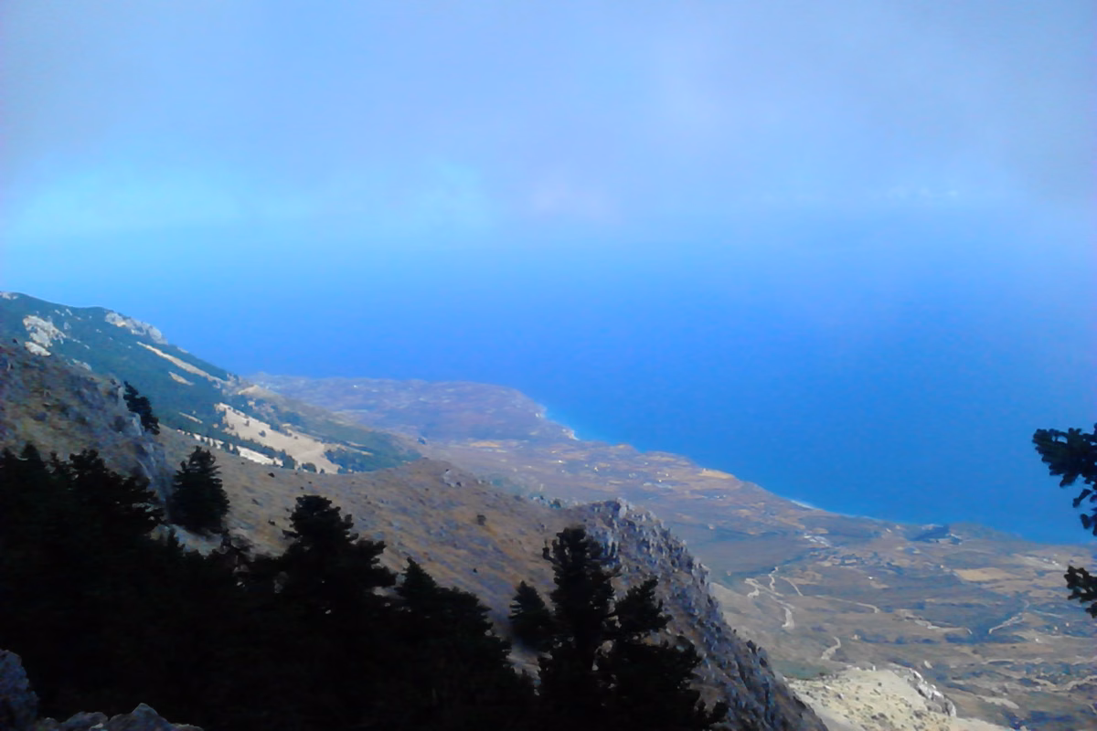 From high on Ainos, firs and rocky slopes fall away to a coastal plain and the sea