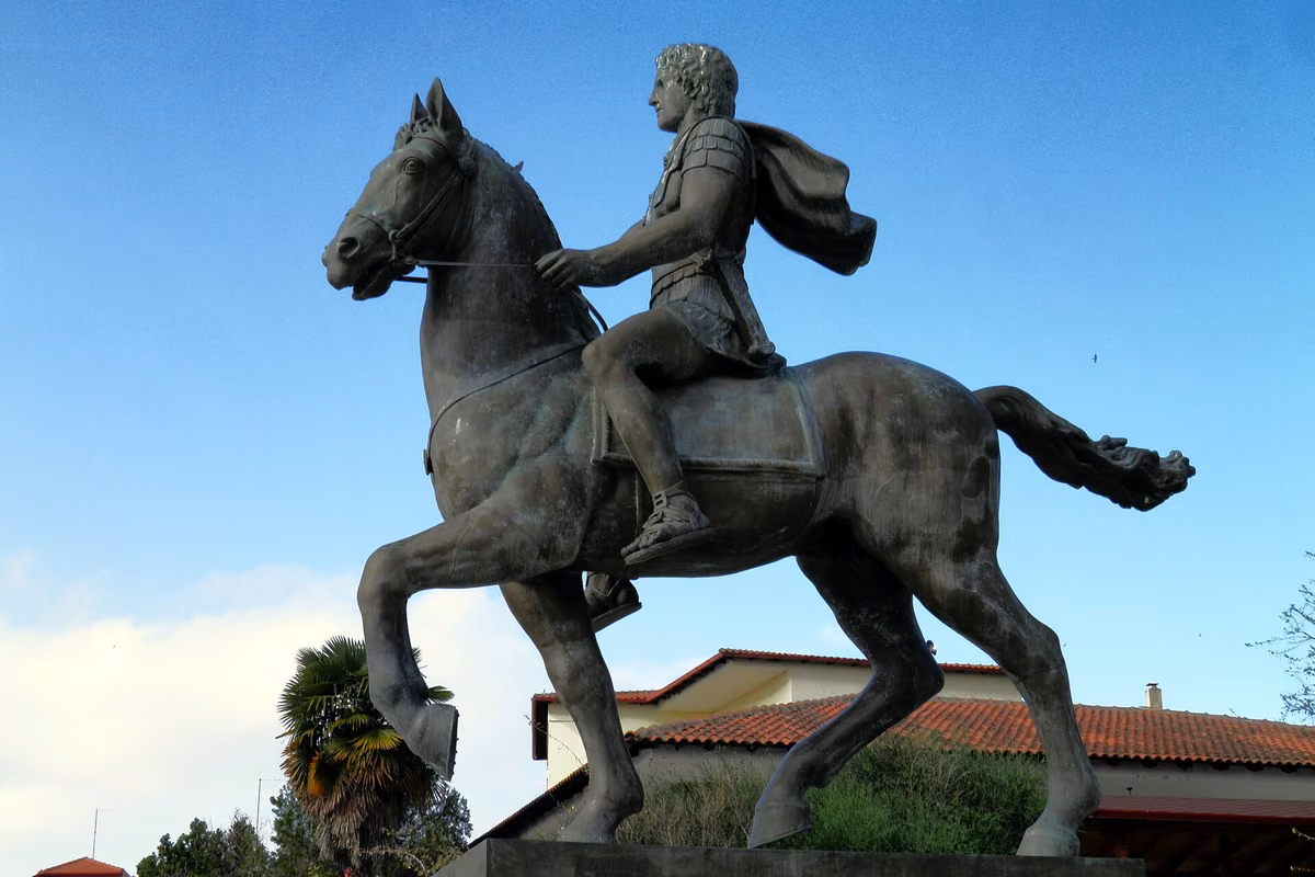 A bronze statue of a rider on a rearing horse against a blue sky