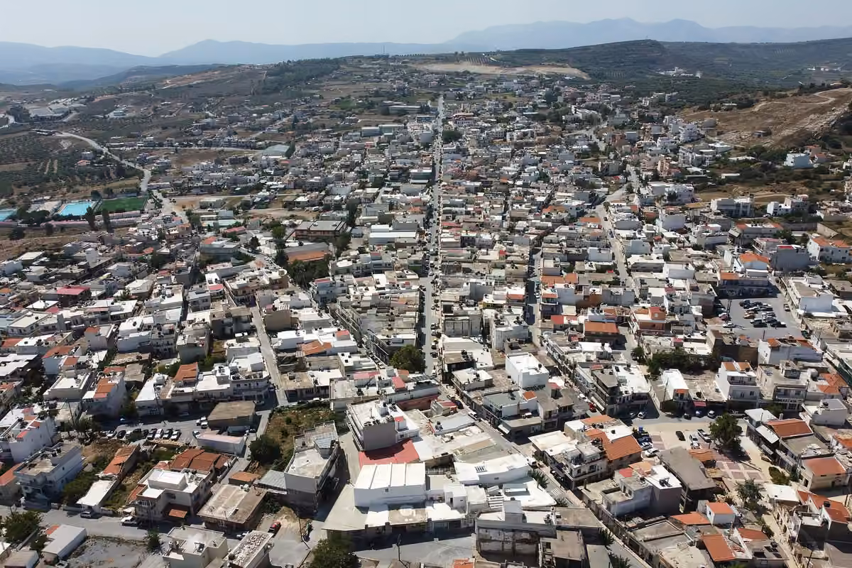 A small town seen from the air, its straight main street running to the hills