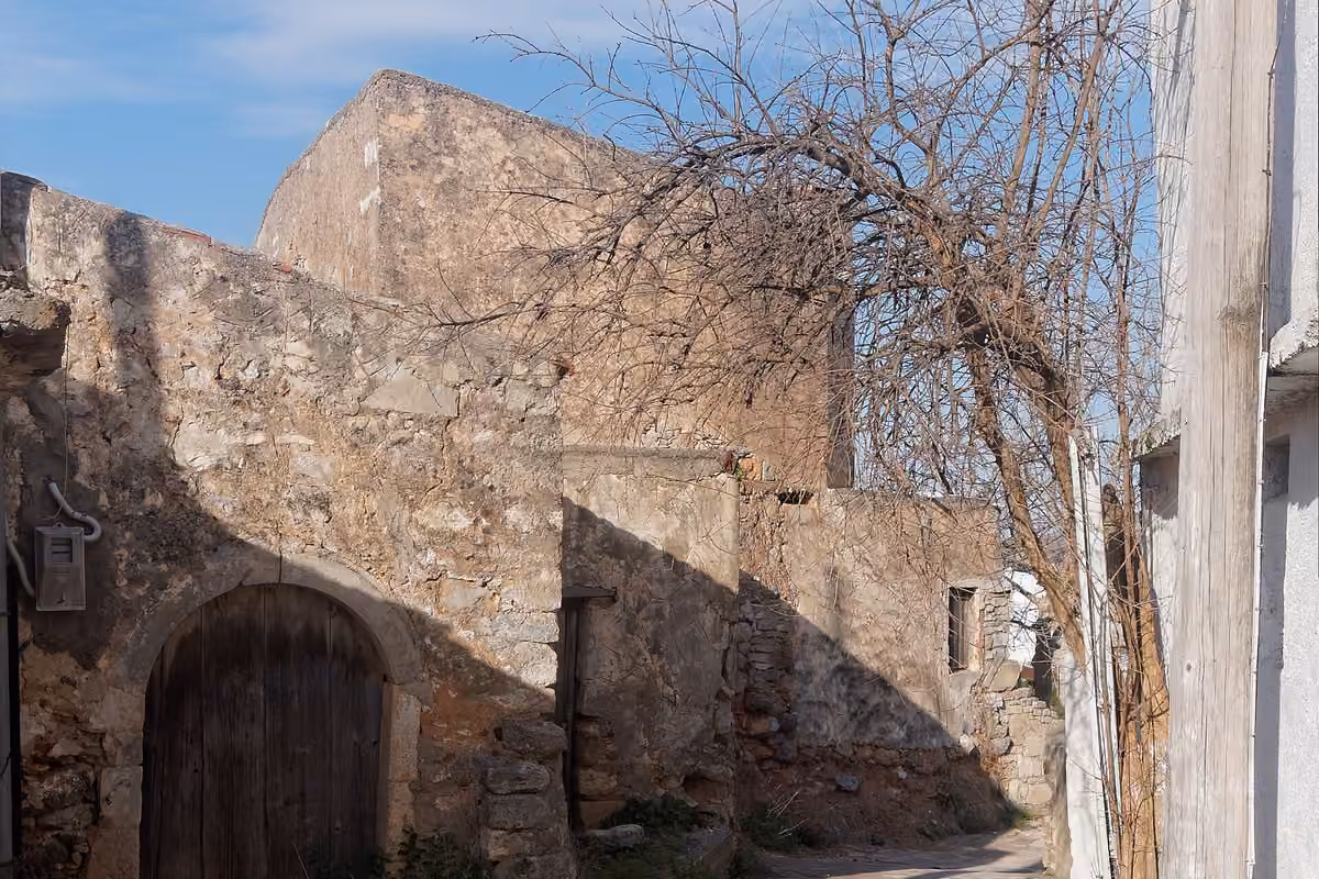 An old stone house and an arched door on a village lane