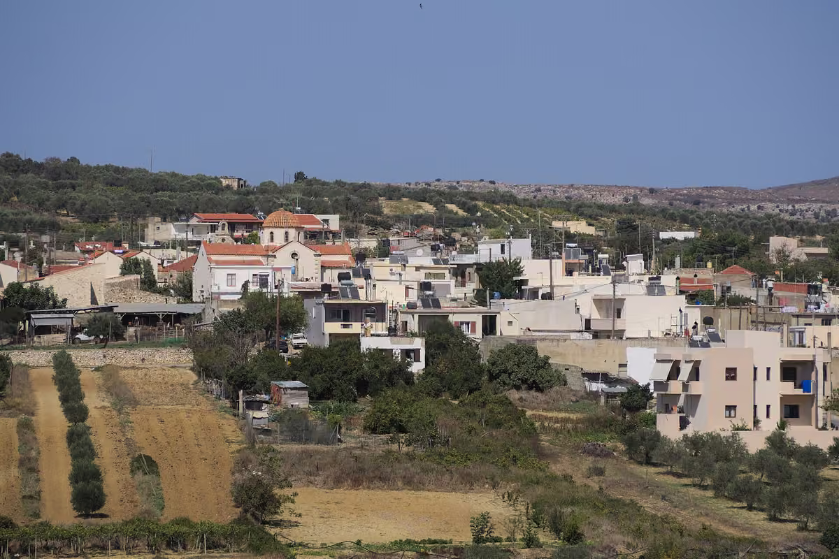 A village of flat-roofed houses above olive terraces