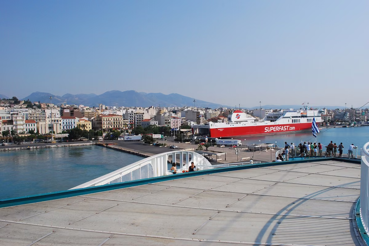 The town of Patras seen from the deck of a ferry, with the port and a red ship
