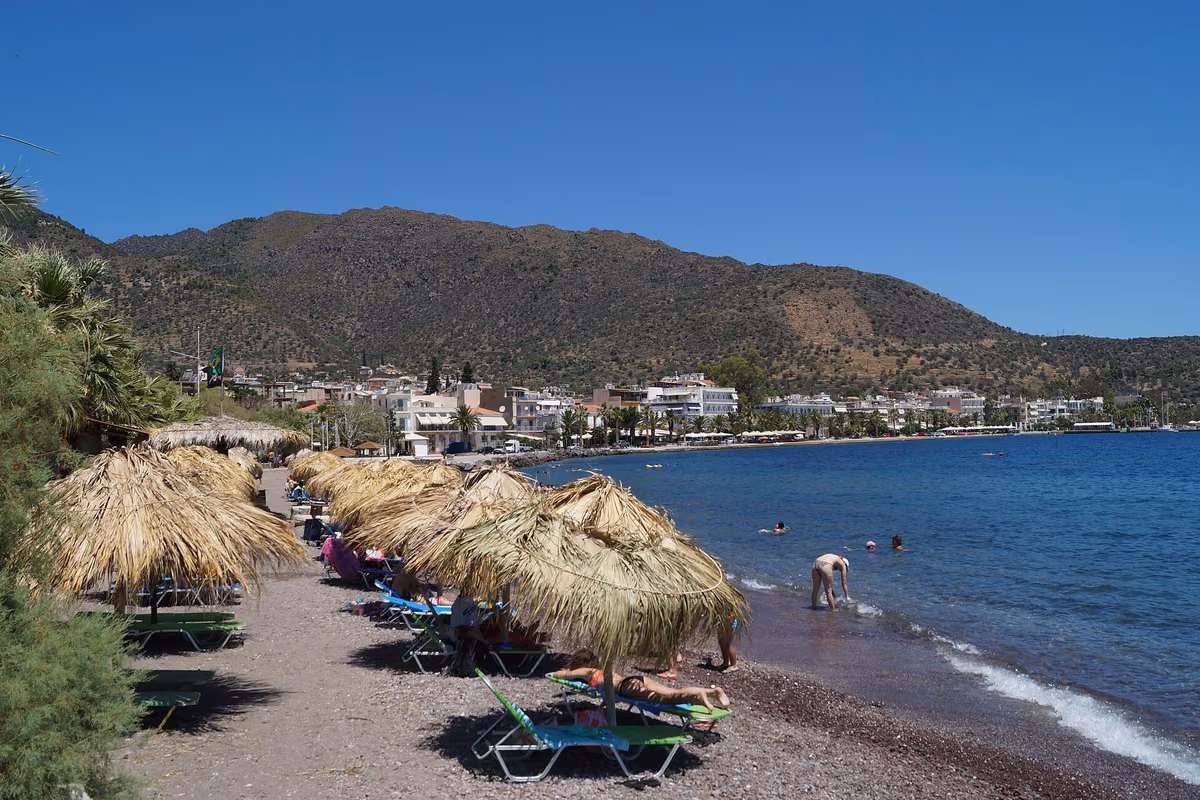 The beach and waterfront of Methana town with the hills behind
